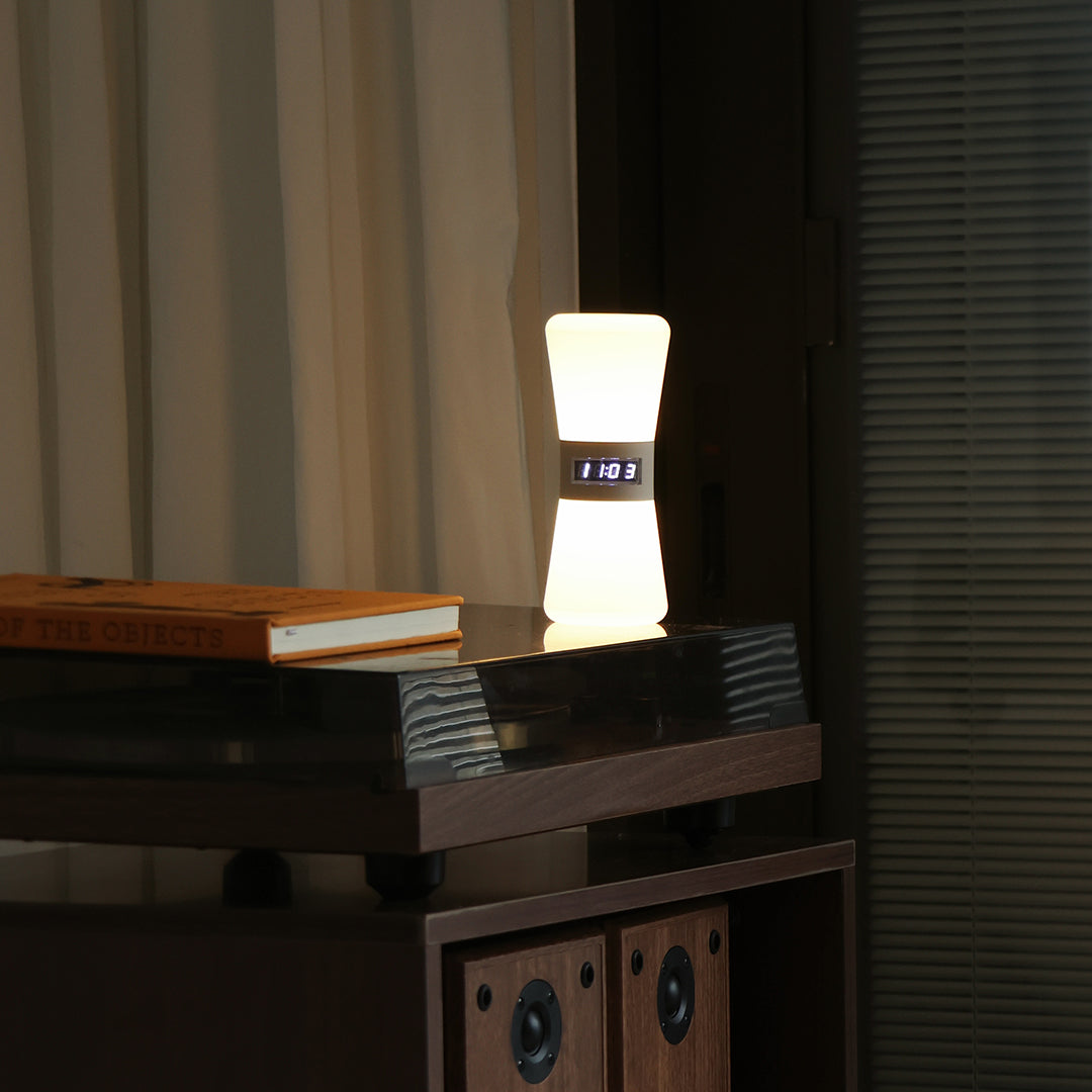 Portable white USB rechargeable table lamp on dark wood surface showing versatile placement