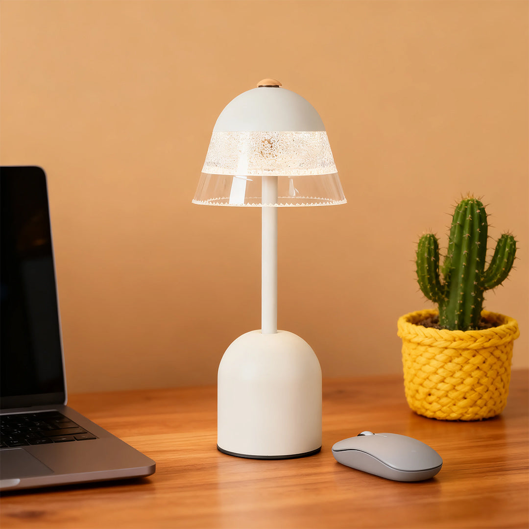 Portable white USB table lamps next to a laptop and a cactus, highlighting its use as a stylish office accessory.