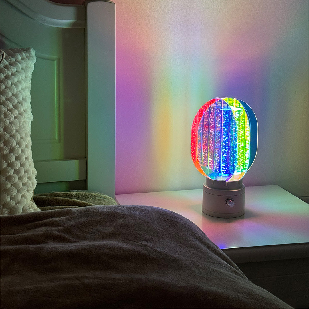 Decorative colourful table lamps with prismatic effect illuminating modern bedroom nightstand setup