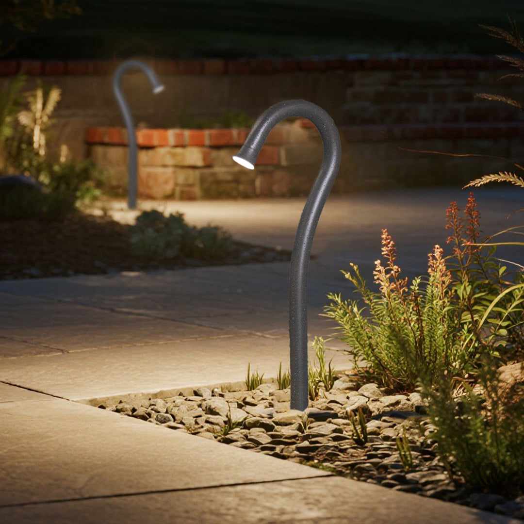 Professional outdoor lighting installation featuring multiple curved fixtures along residential pathway