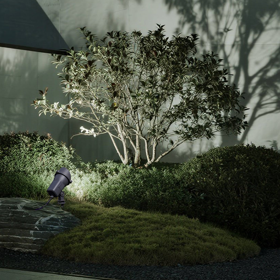 Professional landscape spotlight installed in green lawn area for precise garden accent lighting