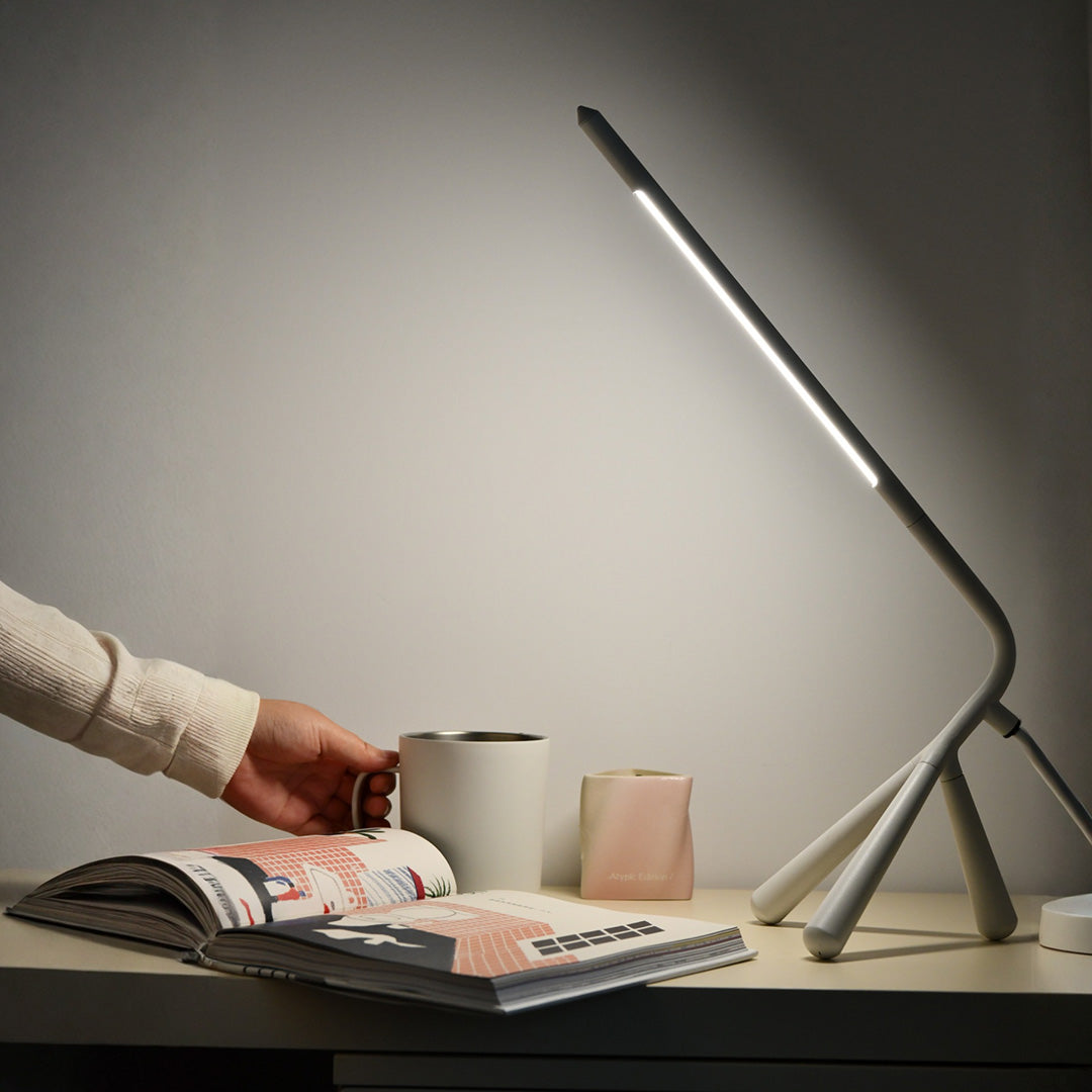 Professional three legged table lamp providing focused lighting for laptop workspace and reading