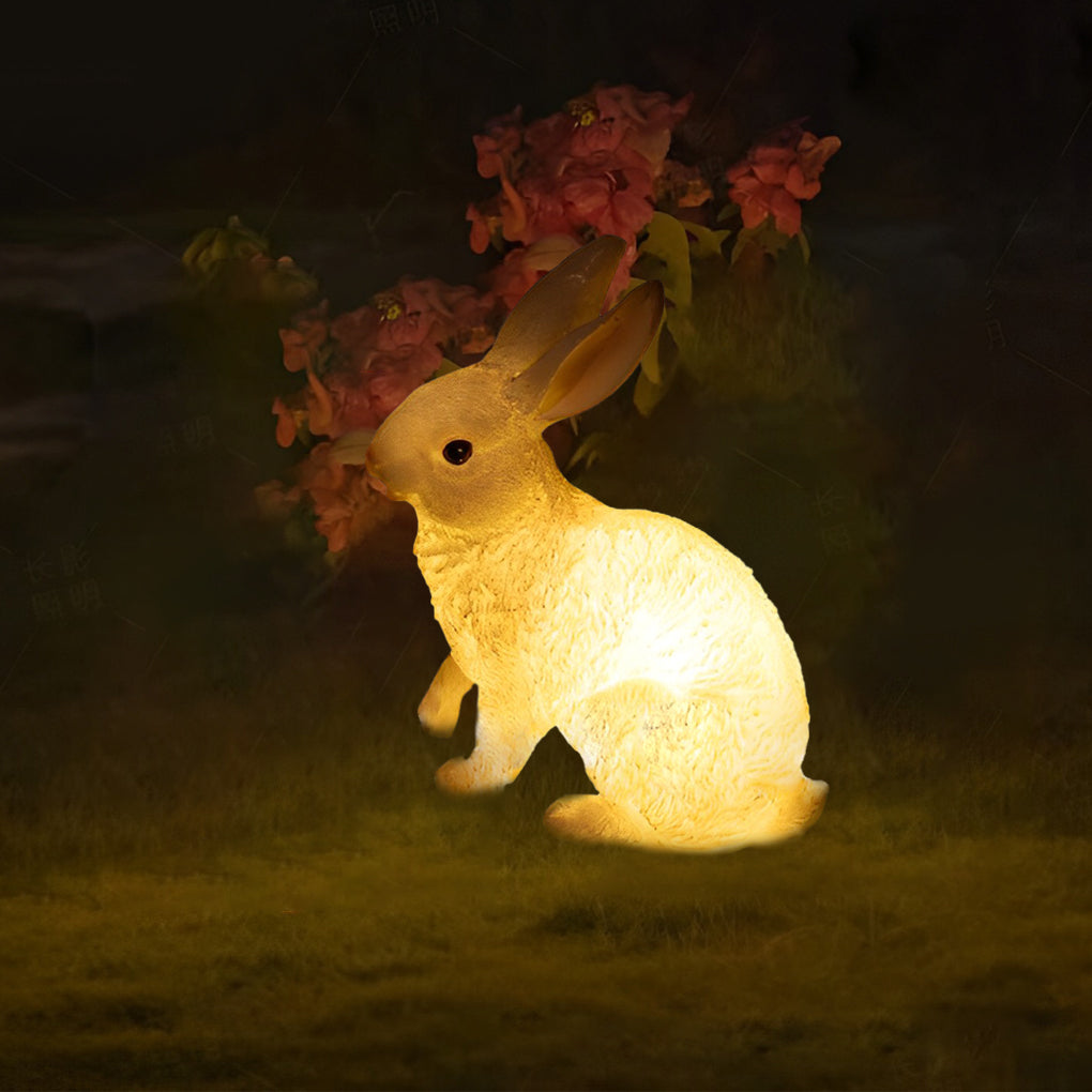 Rabbit garden light with autumn leaves on its head, adding a whimsical touch to the garden.