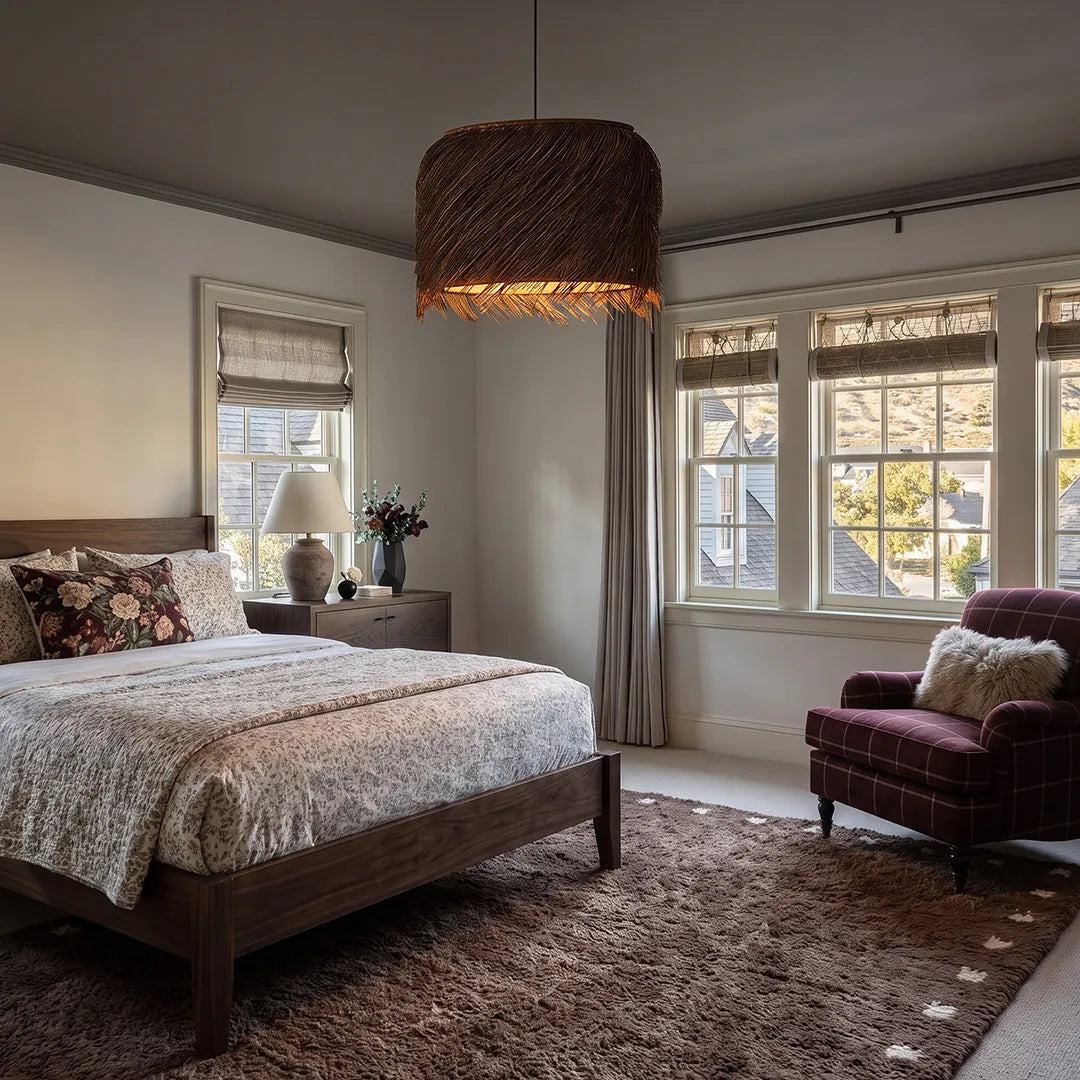 Rattan lighting pendants hanging above a cozy bedroom with a soft rug and warm natural textures.