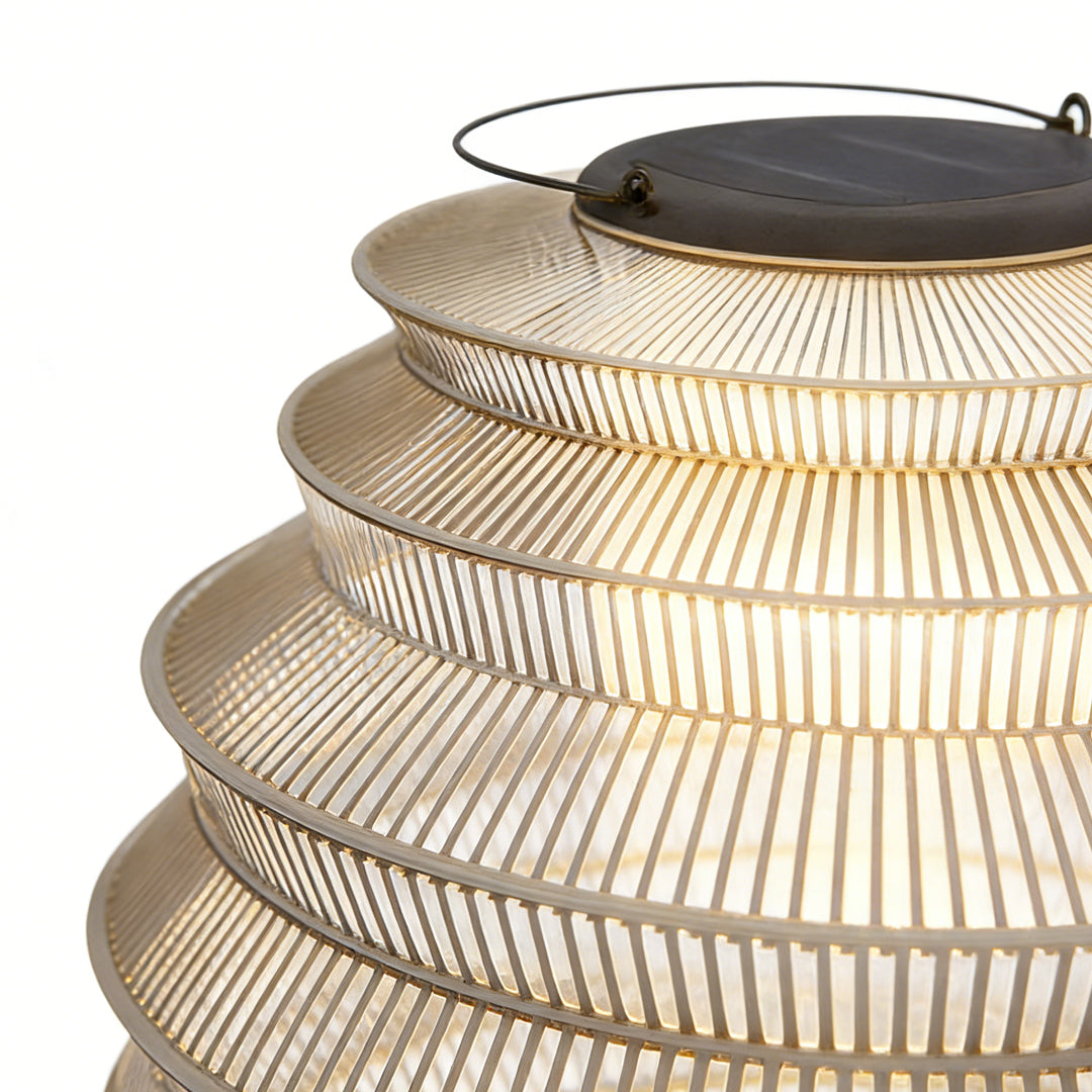 Rattan outdoor lantern with a minimalist design, enhancing an outdoor seating area.