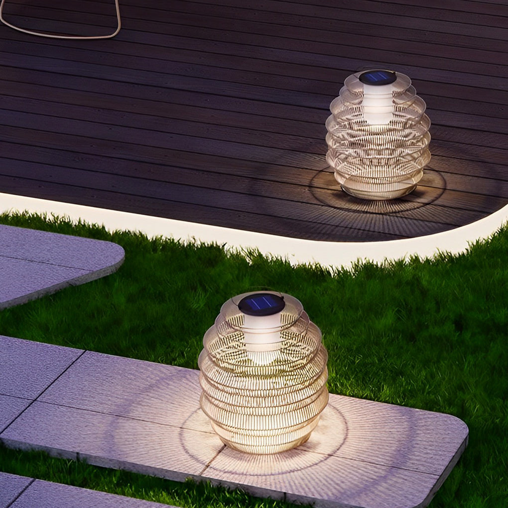 Rattan outdoor lantern with a natural finish, providing ambient light on a lawn.