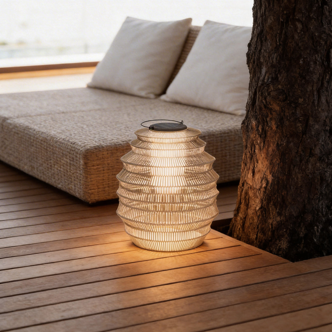 Rattan outdoor lantern with a sleek design, placed beside a lounge chair.