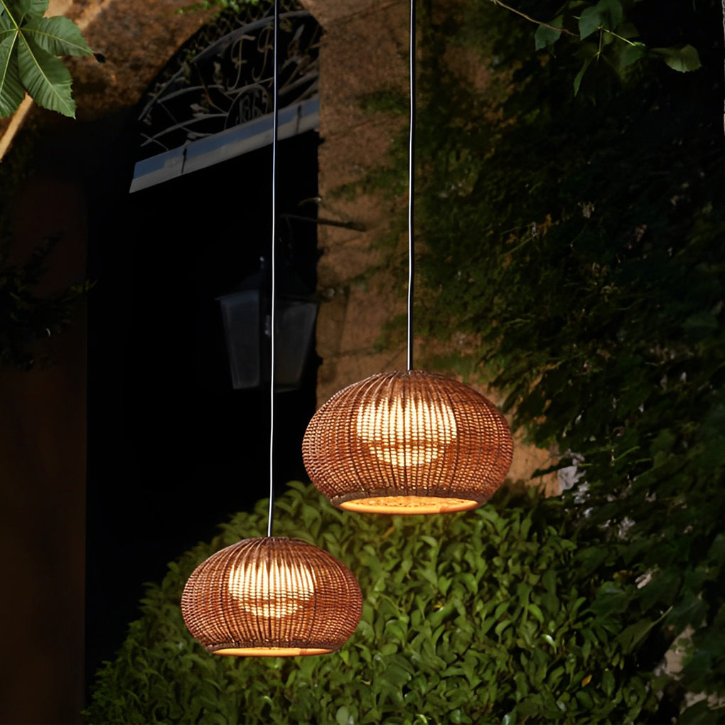 Rattan outdoor pendant light hanging above a table, creating a cozy outdoor dining atmosphere.