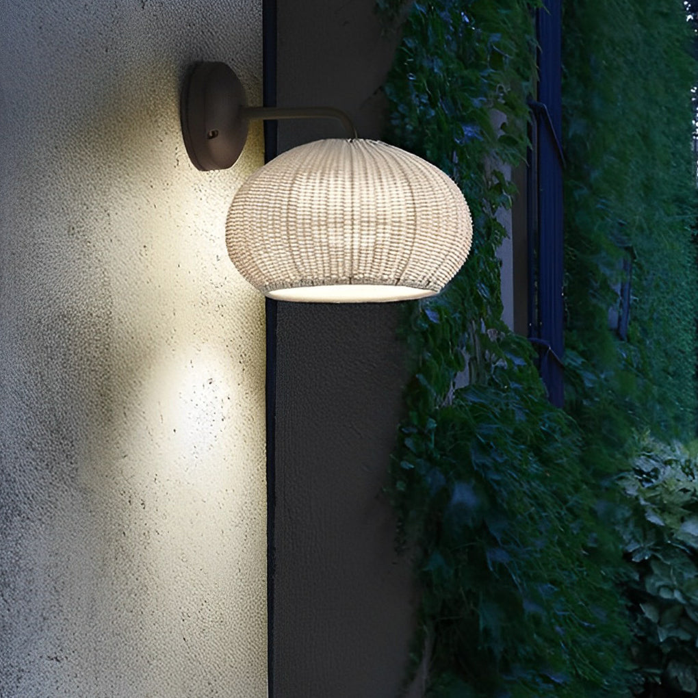 Rattan outdoor pendant light mounted on a wall, providing warm light for an outdoor space.