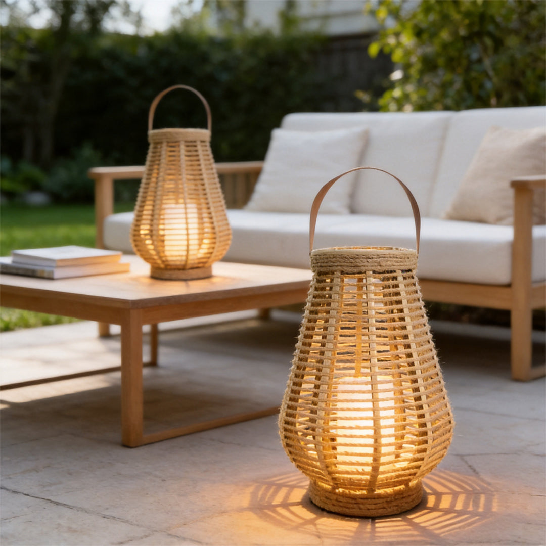 Rattan solar lantern glowing beside a wooden outdoor table and sofa in a cozy patio setting.
