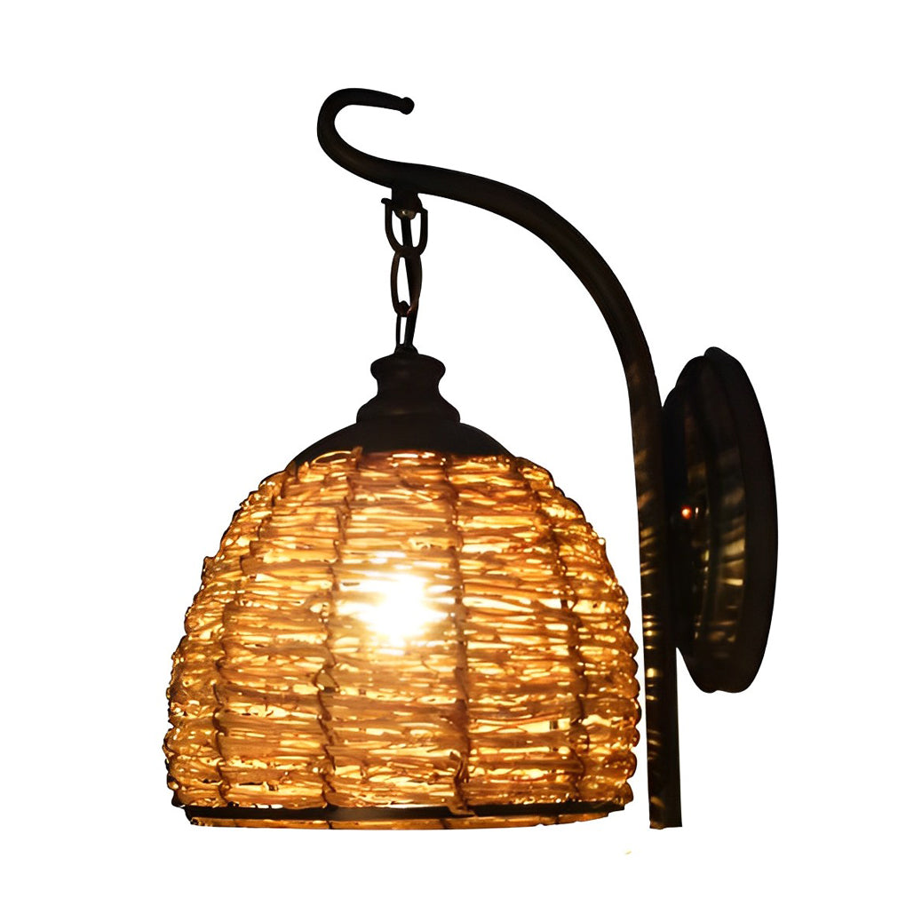Rattan wall lamp with a close-up of its rustic metal arm and woven shade.