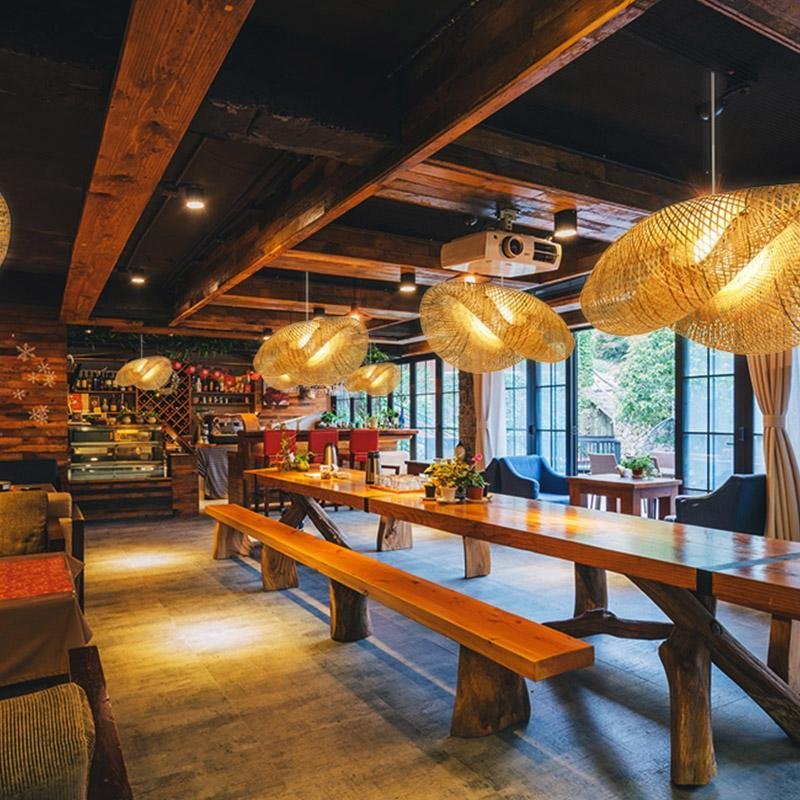 Rattan wave pendant light installed in a rustic restaurant with wooden beams.