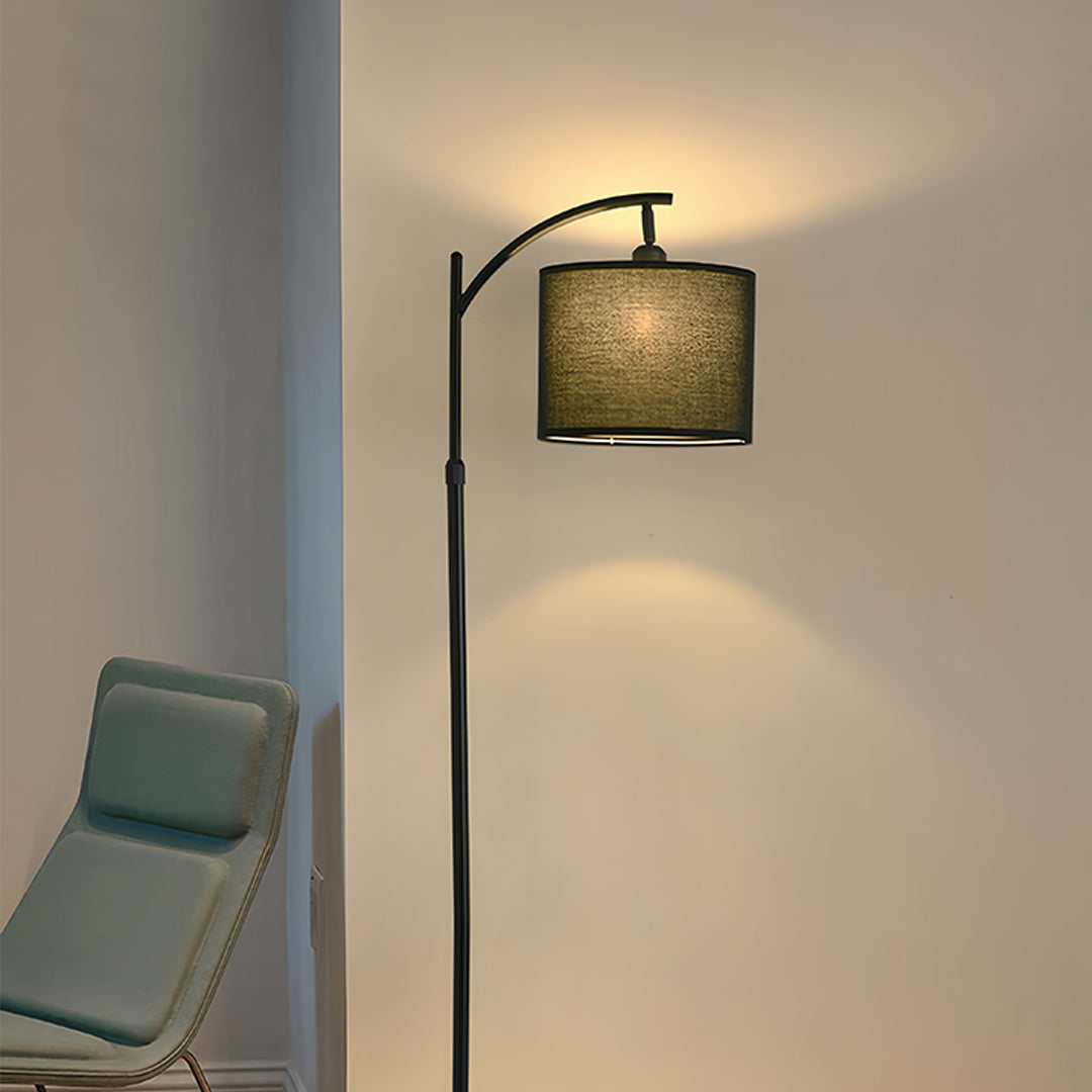 Modern reading corner featuring small black pendant light with beige fabric shade and curved floor lamp design