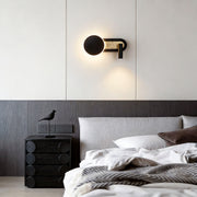 Reading light for bed wall mounted, casting focused light in a modern bedroom with gray accents.