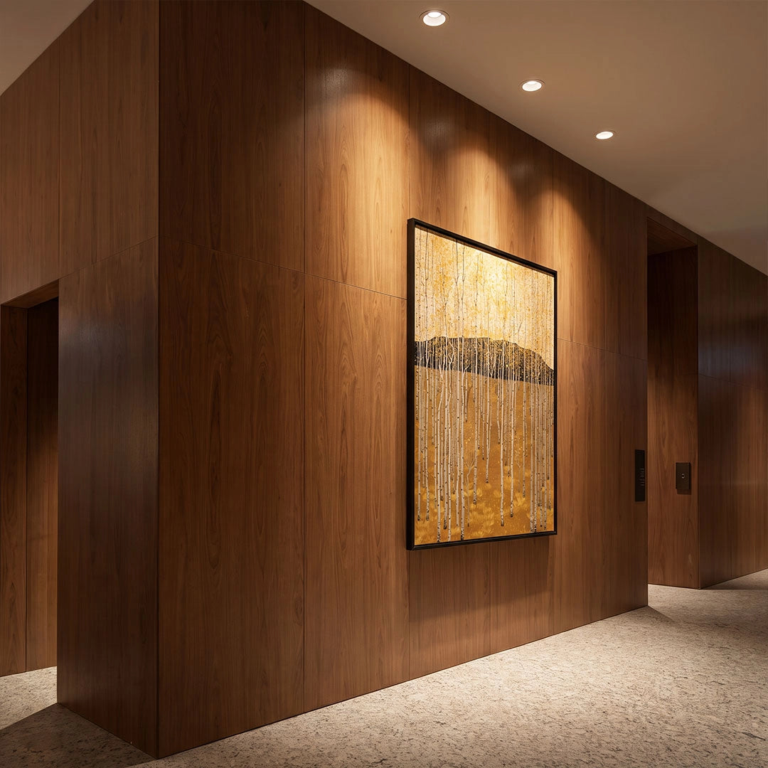 Recessed adjustable downlight fixtures installed in a wood-paneled hallway, creating focused accent lighting over wall art.