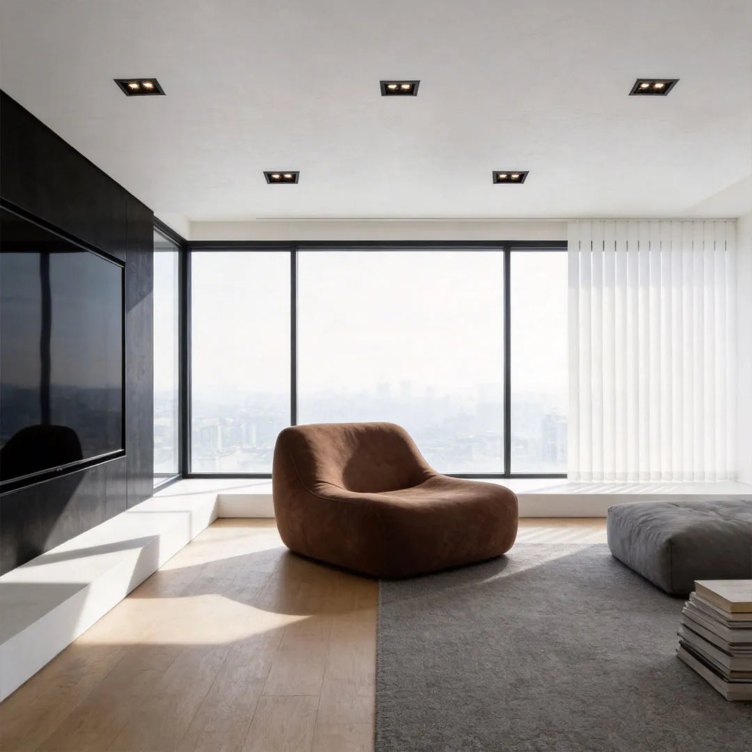 Recessed ceiling spot lights providing focused illumination in a modern living room with floor-to-ceiling windows.