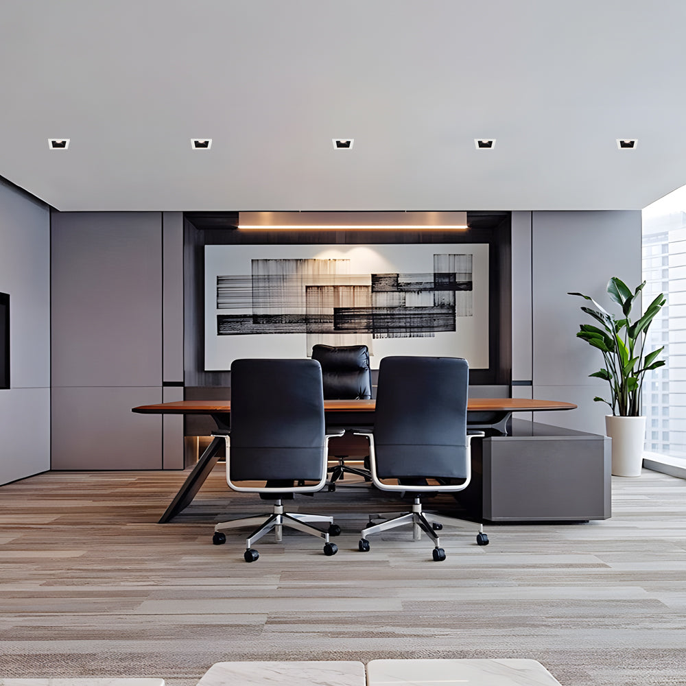 Recessed ceiling spot lights above a contemporary office meeting table with clean ceiling design.