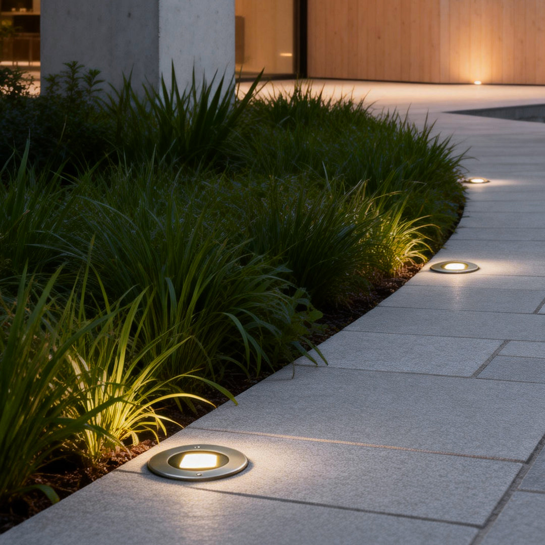 Recessed deck step lights illuminating a garden pathway with a soft, warm glow.