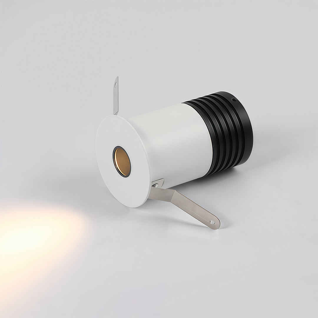 Recessed LED ceiling light detail view showing white adjustable fixture with brass connector hardware