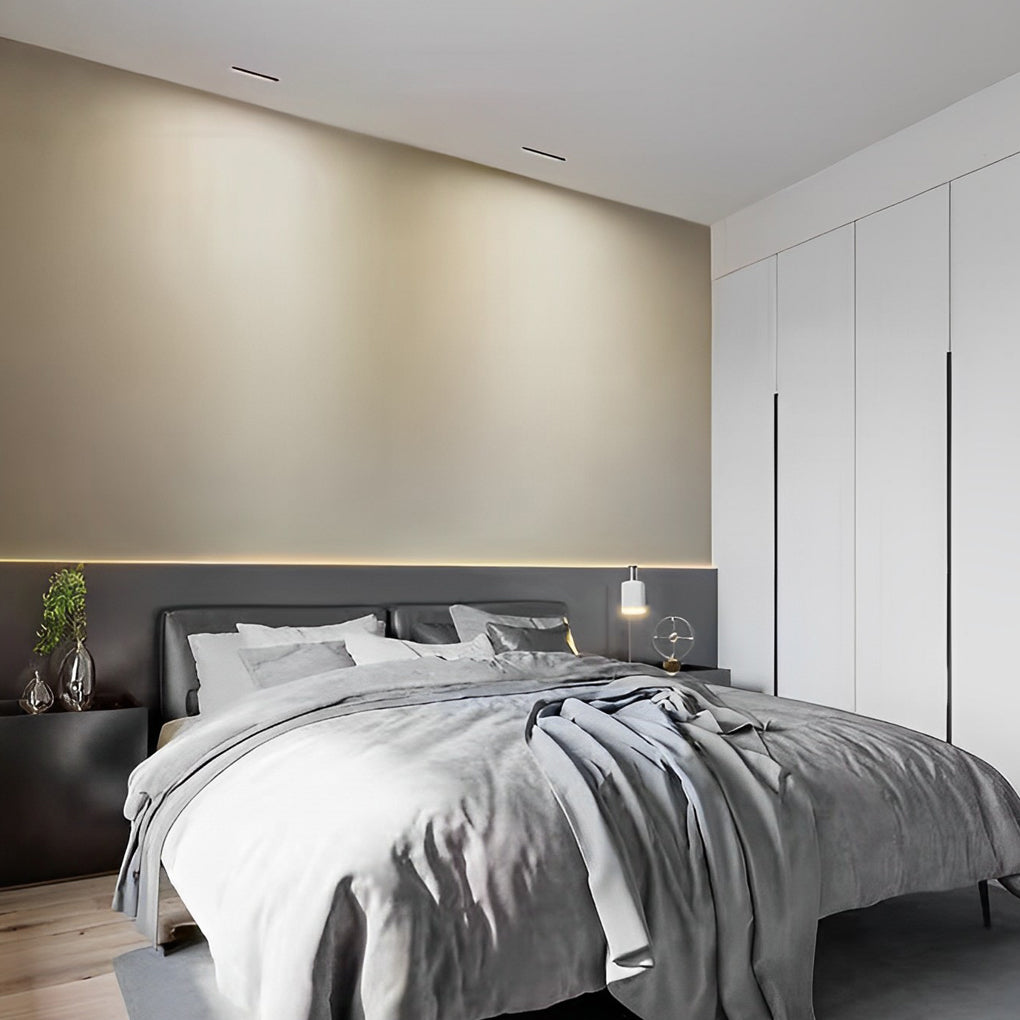 Slim recessed linear light fixture providing ambient lighting in a bedroom