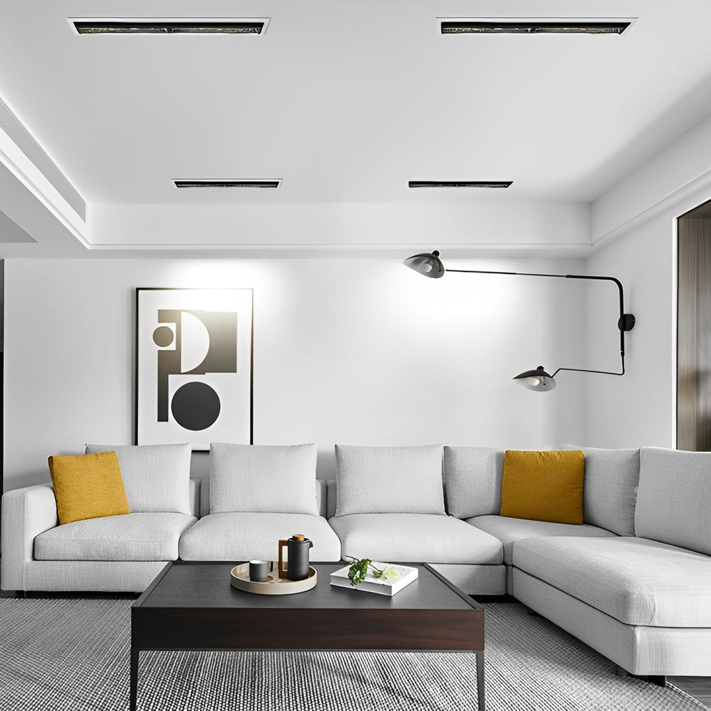 Recessed linear light fixtures evenly illuminating a contemporary living room