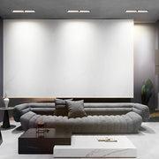 Recessed linear light fixtures installed in a modern living room ceiling