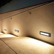 Recessed rectangular pathway light illuminating outdoor walkway with soft downward light distribution