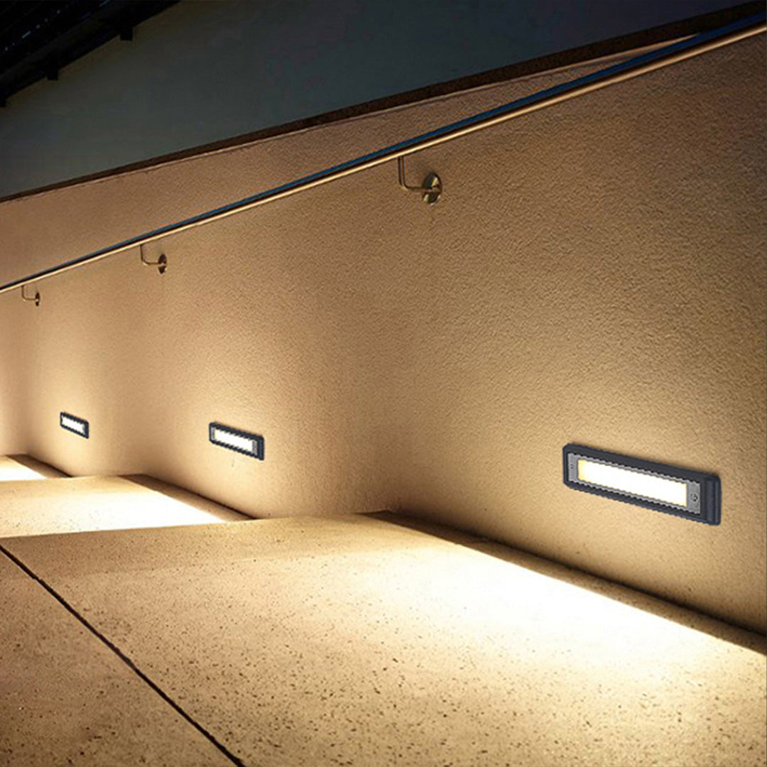 Recessed rectangular pathway light illuminating outdoor walkway with soft downward light distribution