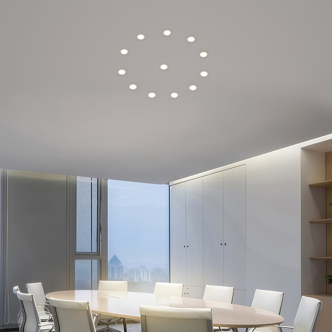 Circular arrangement of recessed ceiling spotlights creating decorative lighting pattern on gray ceiling