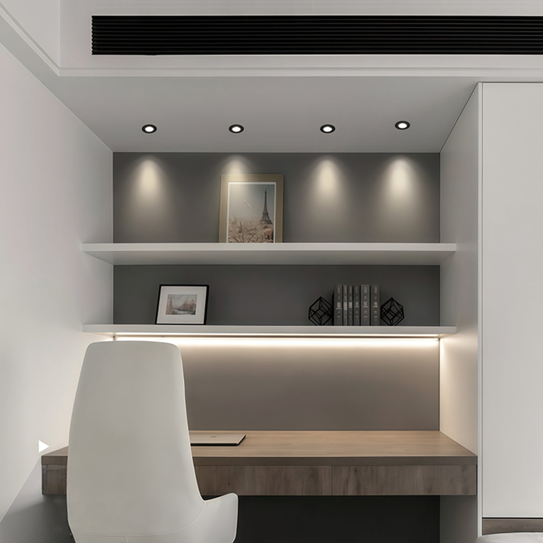 Recessed ceiling spotlights illuminating contemporary display shelving with focused accent lighting