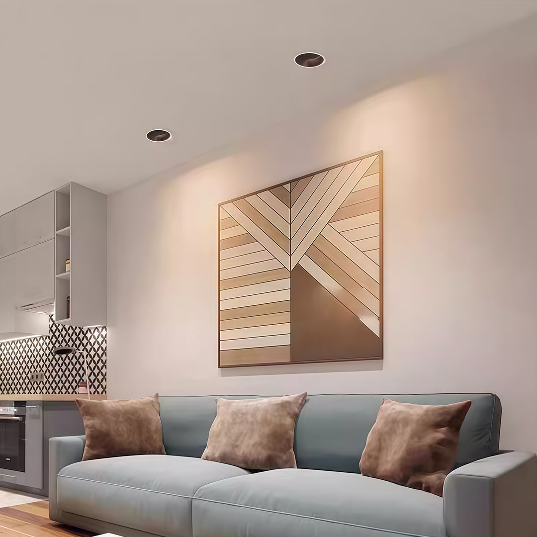Recessed spotlights providing ambient lighting in contemporary living room with woven wall art and grey sofa