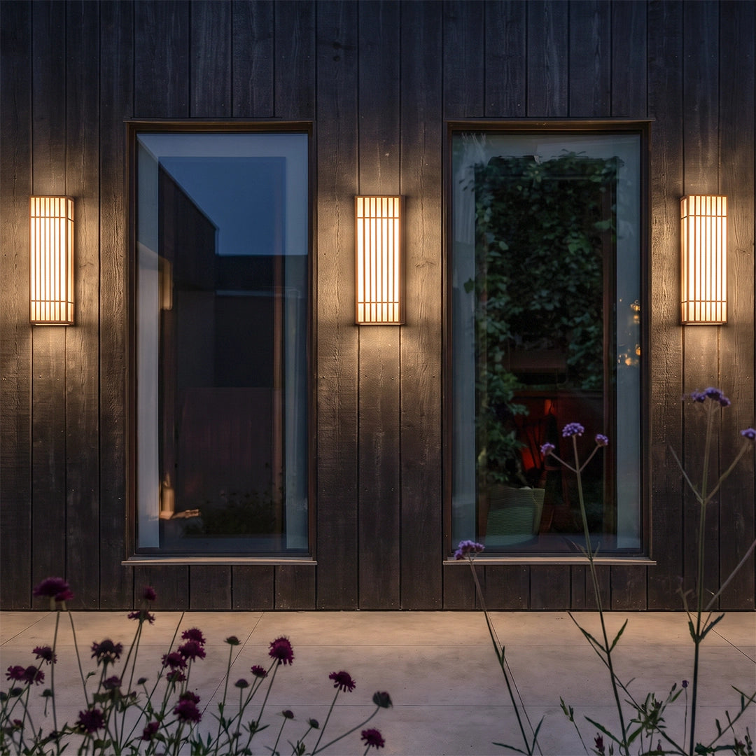 Rectangle LED outdoor wall lights flanking a doorway on a dark exterior wall at night.