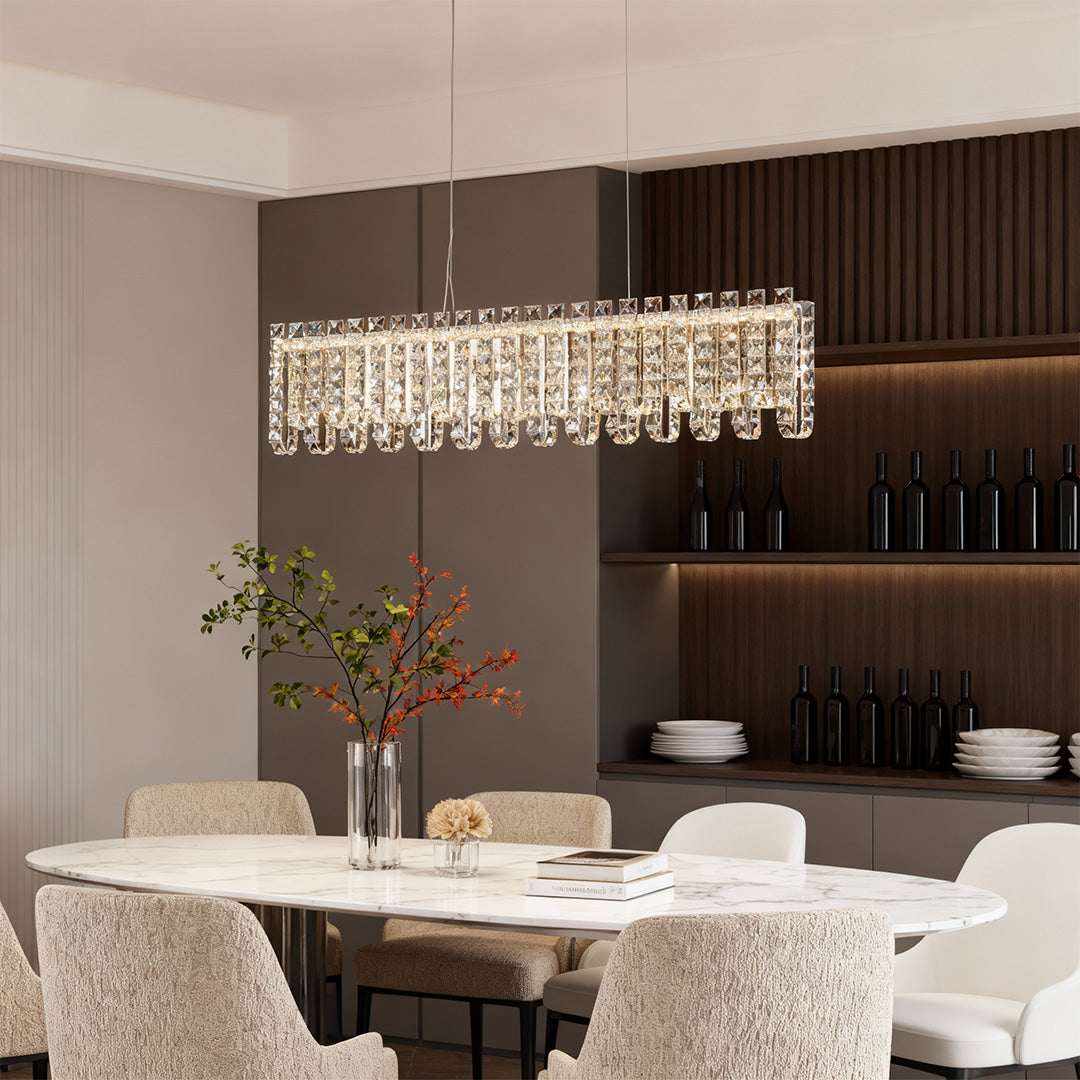 Rectangular crystal chandelier modern hanging above long dining table.