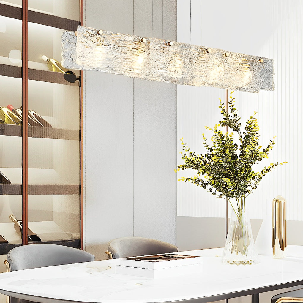 Rectangular glass chandelier with a modern design, providing warm light in a stylish dining room.