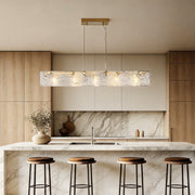 Rectangular glass chandelier with a sleek gold frame, providing elegant illumination above a modern kitchen island.