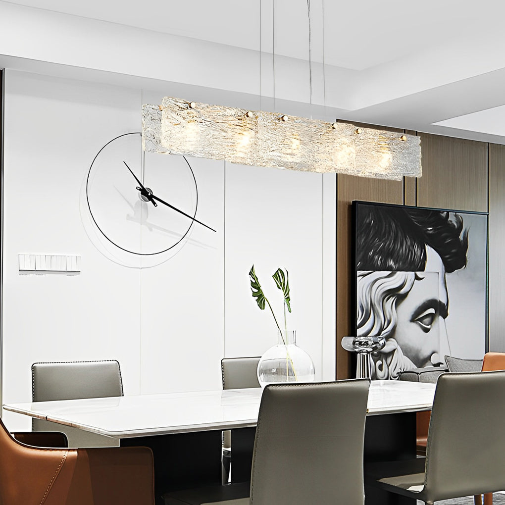 Rectangular glass chandelier with a sleek design, illuminating a white dining table.