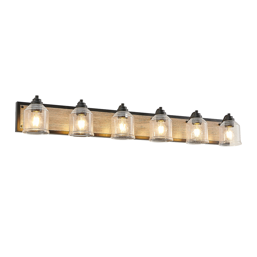 Multi-light wall sconce with clear glass shades, installed above a rectangular bathroom mirror.