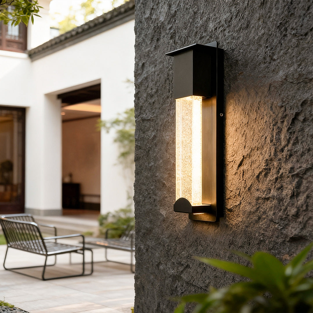 Modern rectangular outdoor wall lights mounted on exterior wall next to garden chair.