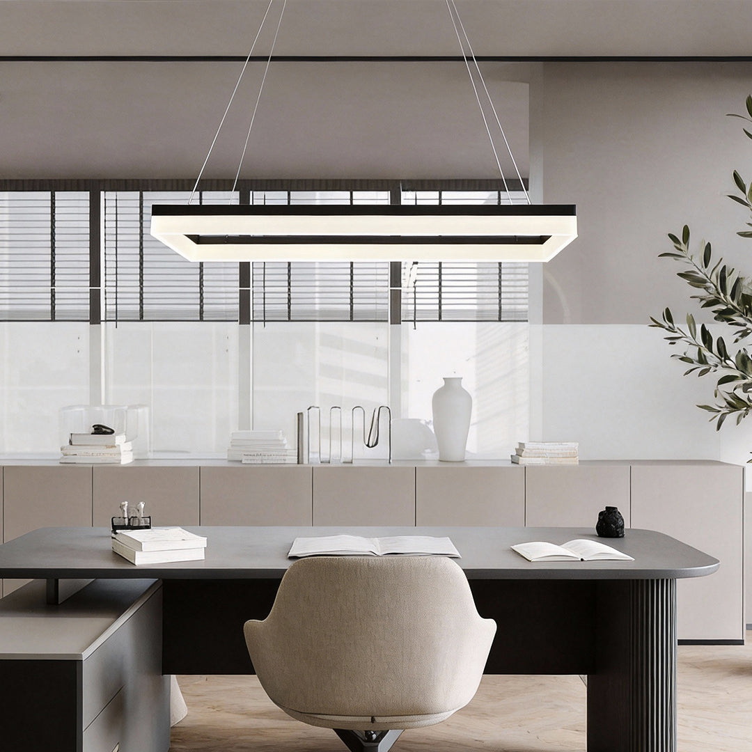 Rectangular pendant light hanging over conference table in minimalist meeting room.
