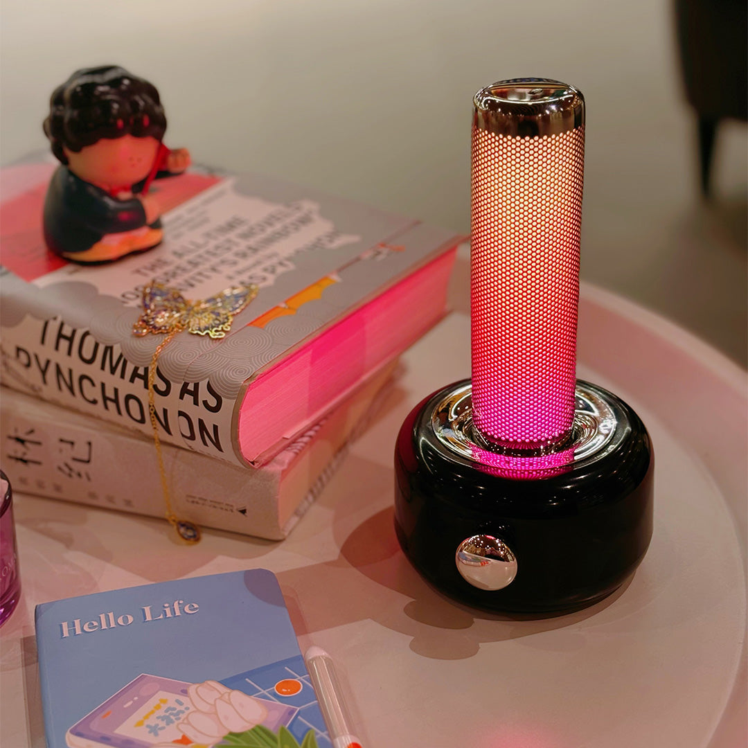 Red industrial metal USB rechargeable table lamp providing warm task lighting on wooden desk