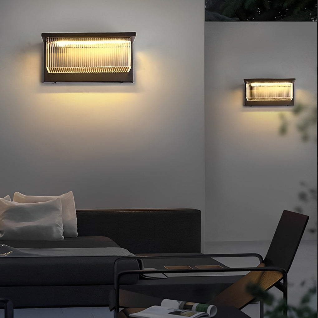 Reeded acrylic sconce illuminating a minimalist outdoor patio with focused glow.