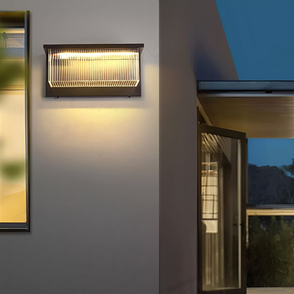 Reeded acrylic sconce providing soft illumination along a stylish outdoor seating area.