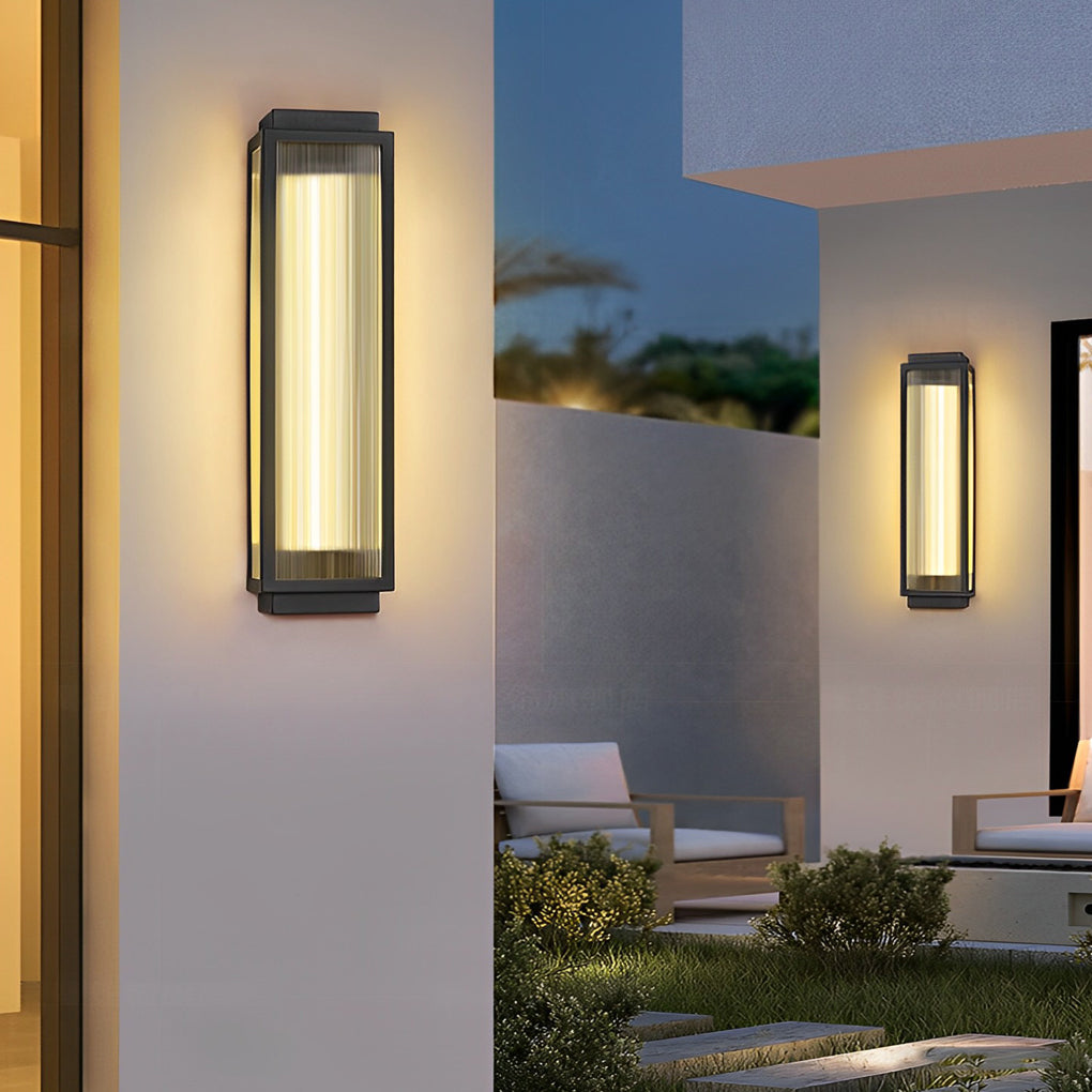 Reeded glass light fixture casting a warm glow on a white exterior wall, perfect for modern homes.