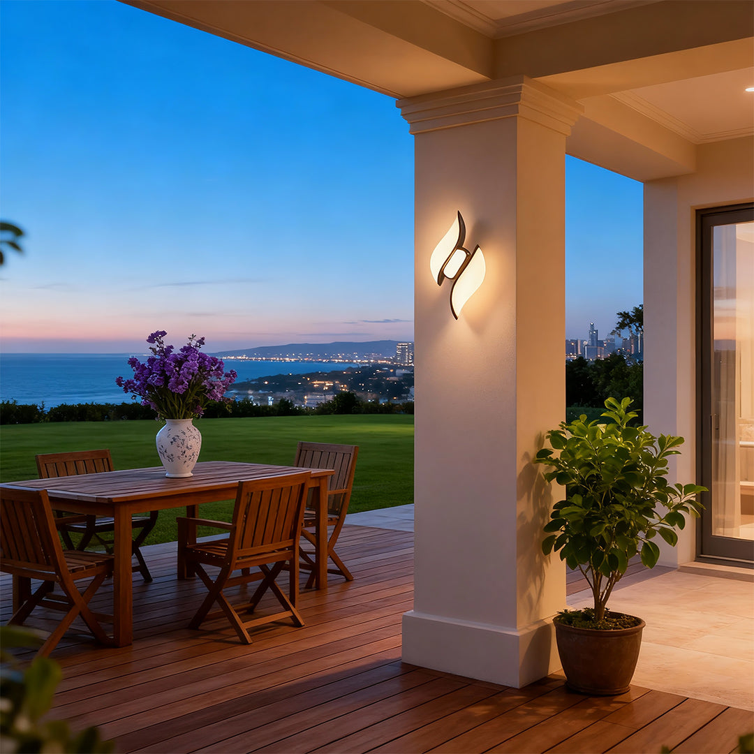 Refined black outdoor wall sconces with glass shade chandelier design illuminating elegant covered patio with ocean vista.
