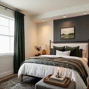 Regressed round recessed LED ceiling downlight installed above a modern bedroom, providing focused illumination over the bed.