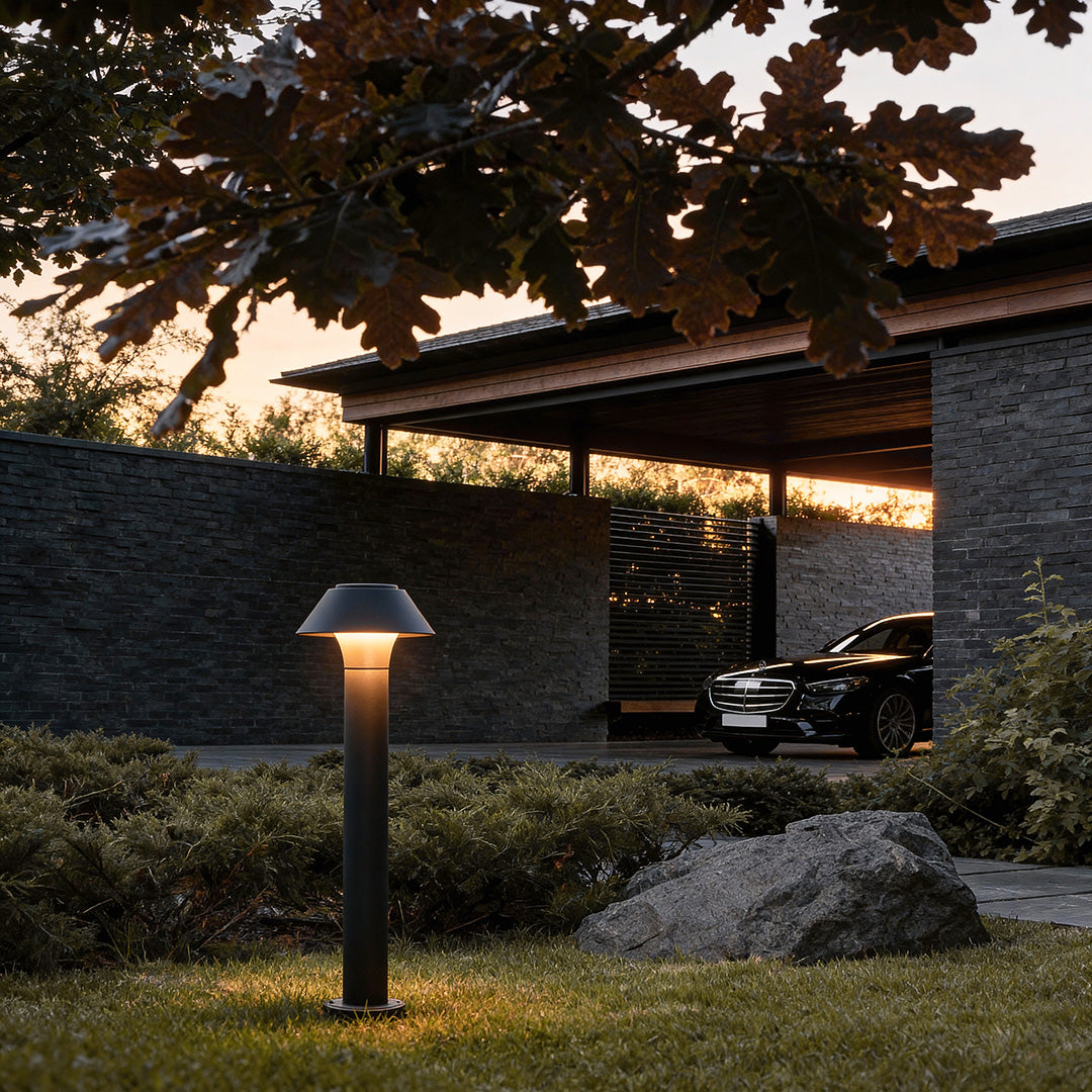 Residential bollard lights installed near a driveway and landscaped yard, creating a warm and welcoming outdoor lighting atmosphere.