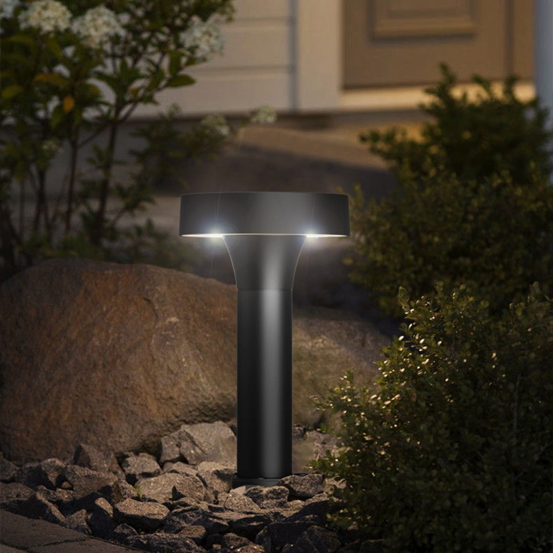 Evening residential setting with bollard lights providing ambient lighting near stone landscaping