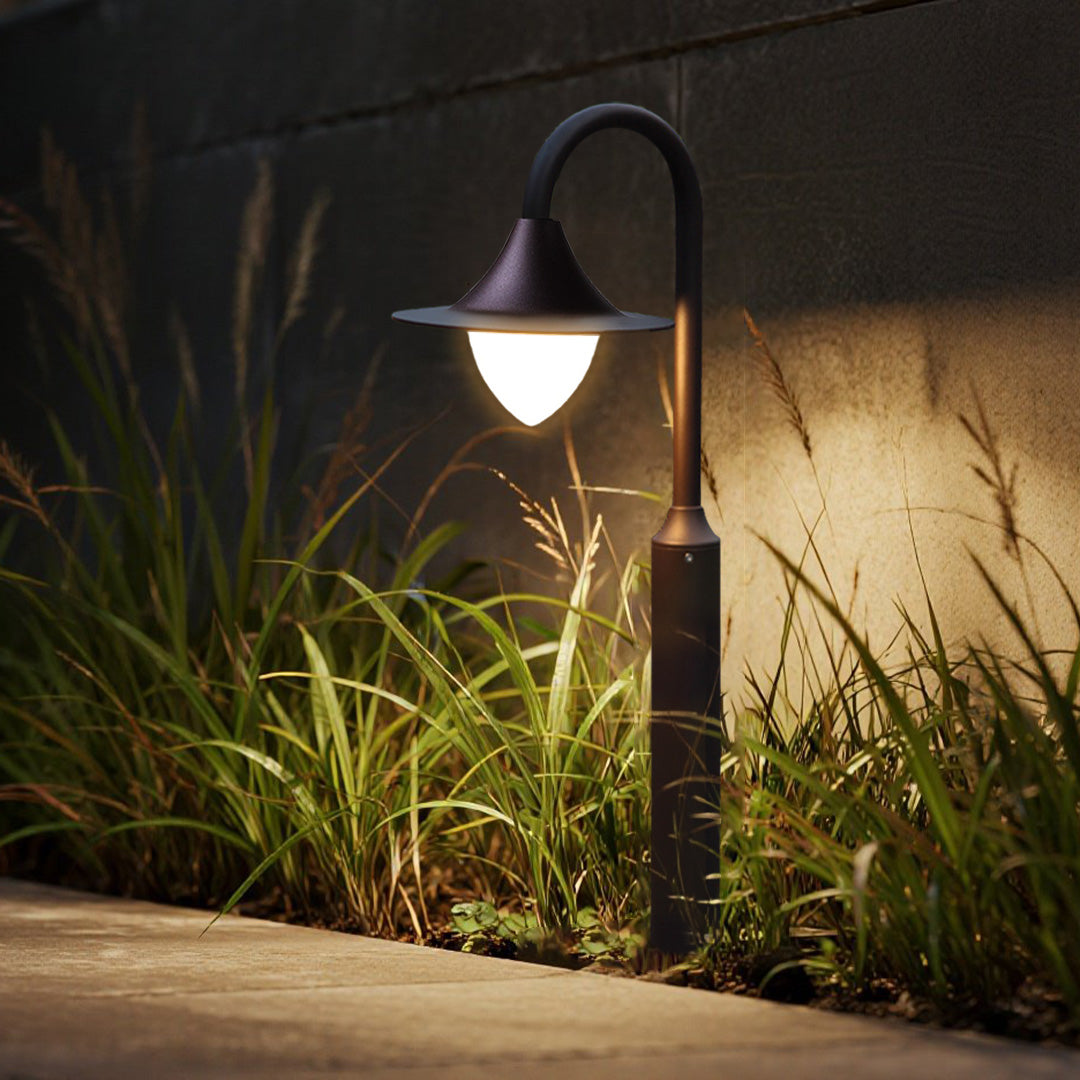 Residential outdoor lighting installation with curved fixtures highlighting natural garden textures