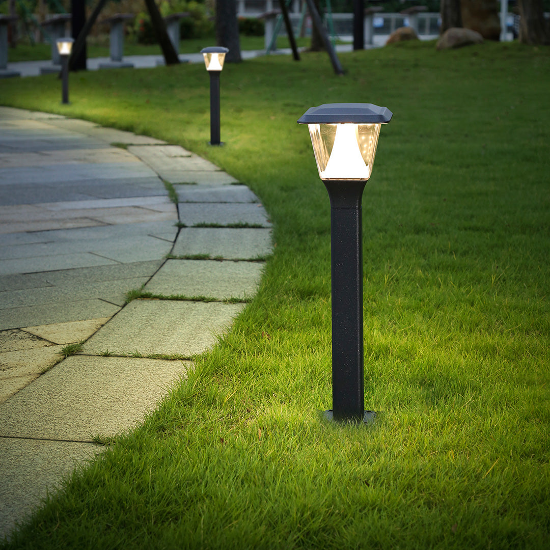 Traditional-style post light illuminating residential lawn area during evening hours