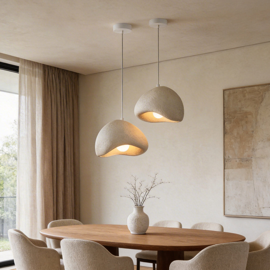 Elegant resin pendant light hanging above a round dining table in a cozy, well-lit room.